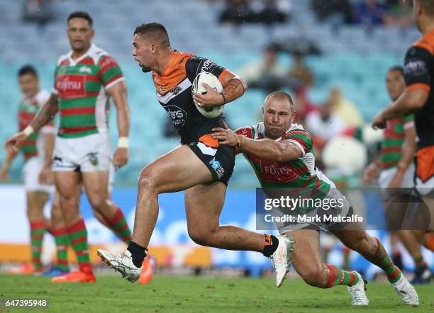 Josh Aloiai of the Tigers is tackled during the round one NRL match between the South Sydney Rabbitohs and the Wests Tigers at ANZ Stadium on March...