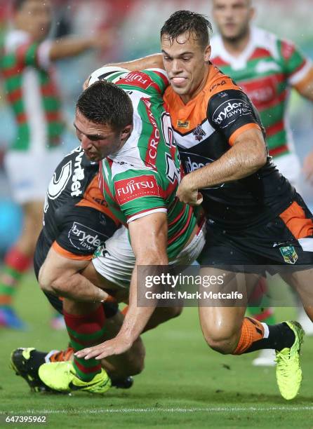 Sam Burgess of the Rabbitohs is tackled by Luke Brooks of the Tigers during the round one NRL match between the South Sydney Rabbitohs and the Wests...