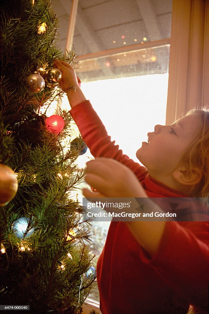 Girl Decorates Christmas Tree