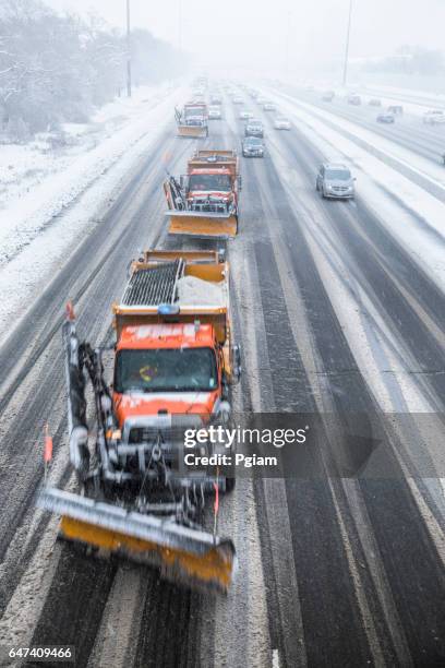 schneepflüge klar eine schnee bedeckten straße - salz streuen stock-fotos und bilder