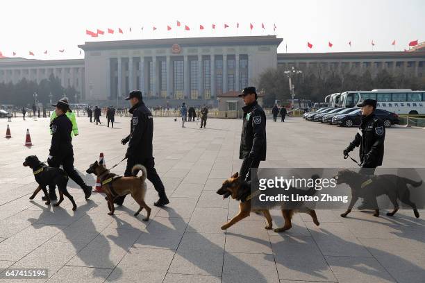 Police officers and dogs patrol outside the Great Hall of the People during the opening ceremony of the Chinese People's Political Consultative...