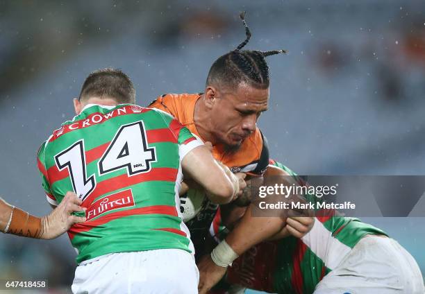 Sauaso Sue of the Tigers is tackled during the round one NRL match between the South Sydney Rabbitohs and the Wests Tigers at ANZ Stadium on March 3,...