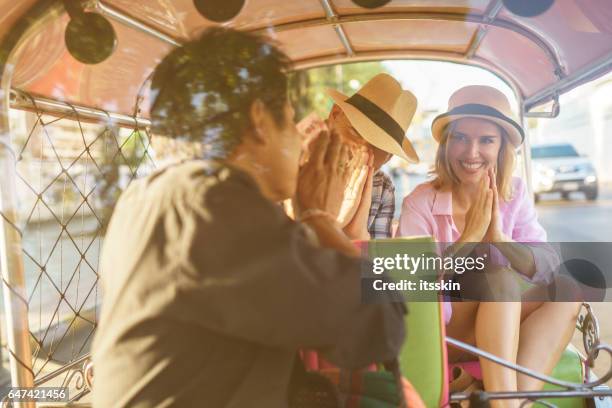 middle-aged man and his companion handsome blond lady on a tuk-tuk ride in bangkok - auto rickshaw stock pictures, royalty-free photos & images