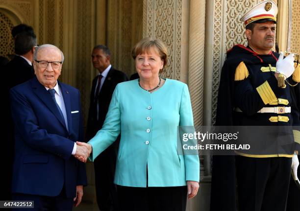 Tunisian President Beji Caid Essebsi greets German Chancellor Angela Merkel on March 3, 2017 upon her arrival in Carthage, on the outskirts of Tunis....