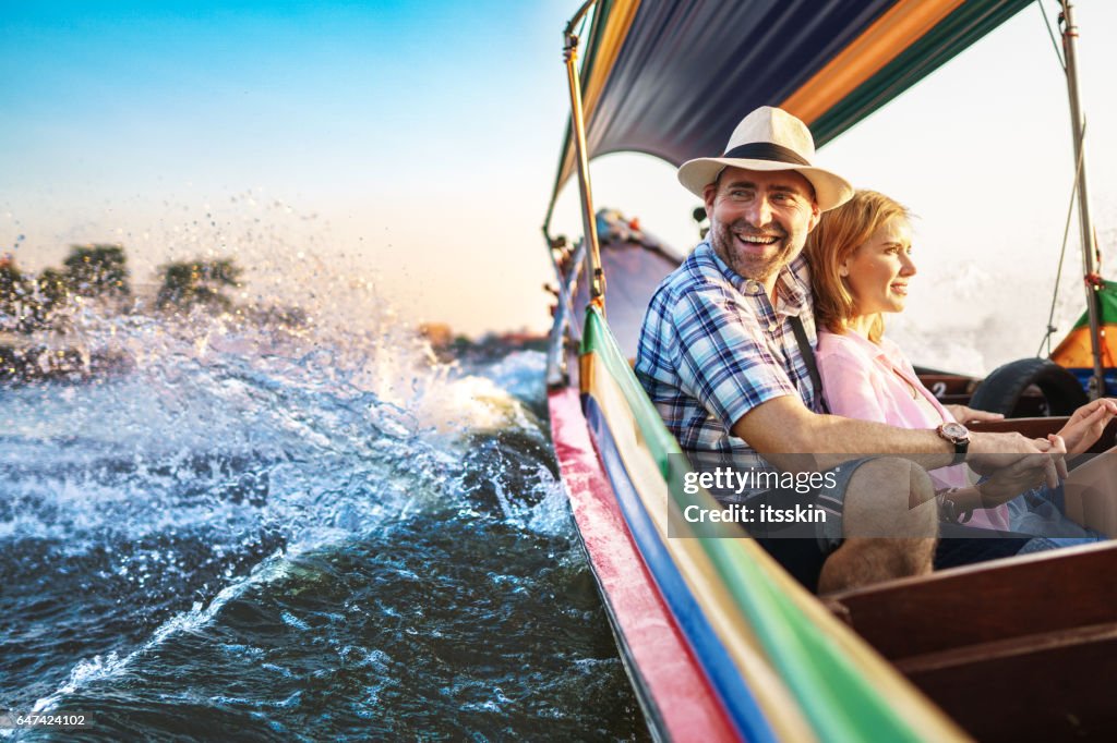 Man van middelbare leeftijd en zijn metgezel knappe blonde dame op een boot rit in Bangkok