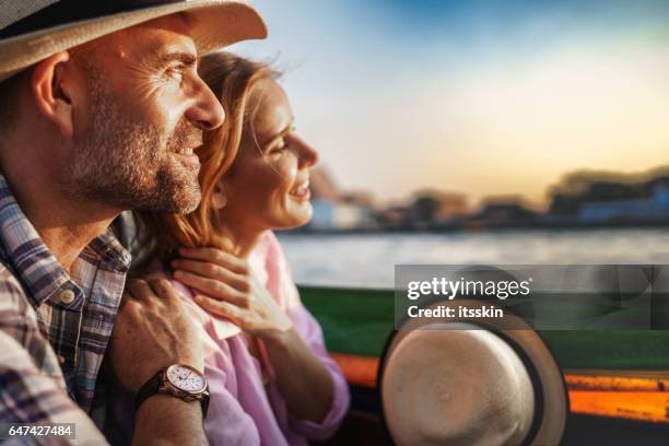 middle-aged man and his companion handsome blond lady on a boat ride in bangkok - tourboat stock pictures, royalty-free photos & images