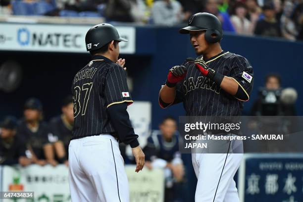 Infielder Sho Nakata of Japan high fives with coach Toshihisa Nishi after his solo homer in the top of the seventh inning during the World Baseball...