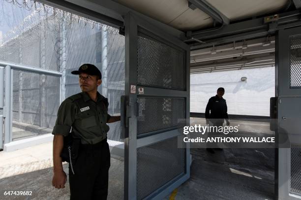 In this picture taken on March 2 a prison guard opens a secure gate leading from a block of cells inside Stanley Prison in Hong Kong. Stanley Prison,...