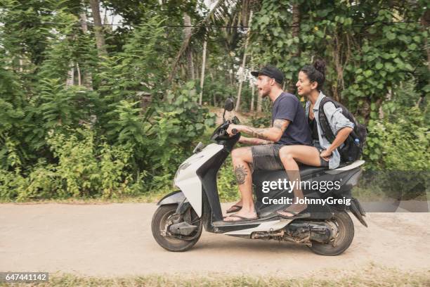 mid volwassen paar rijden bromfiets door bos, zijaanzicht - sabbatical stockfoto's en -beelden