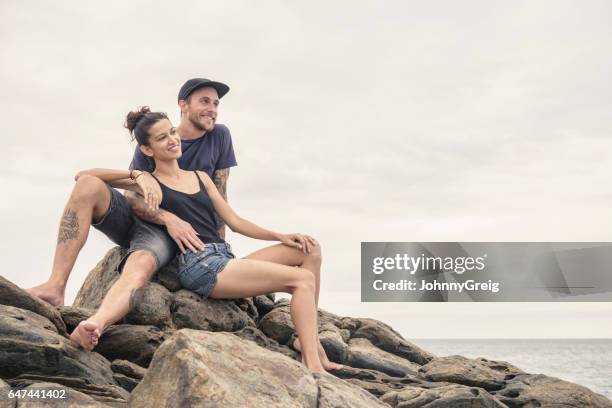 mid adult couple sitting on rocks looking at view - tee srilanka stock pictures, royalty-free photos & images