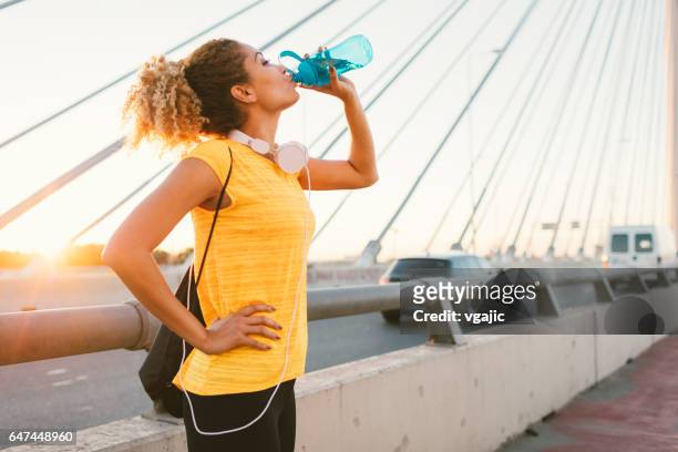 latina runner - drinking water outside stock pictures, royalty-free photos & images