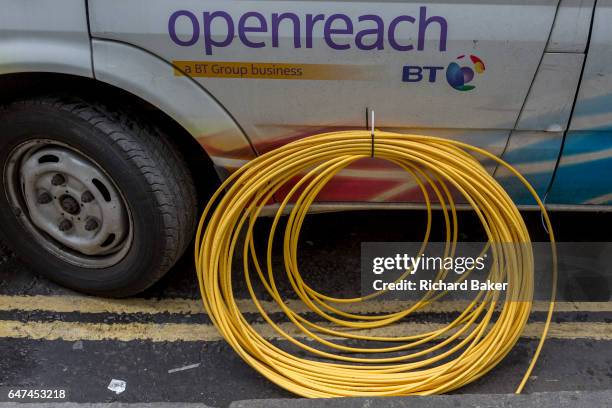 Detail of a BT Openreach van and a coil of yellow broadband fibre cable on the ground and awaiting installation, on 16th February 2017, in the City...