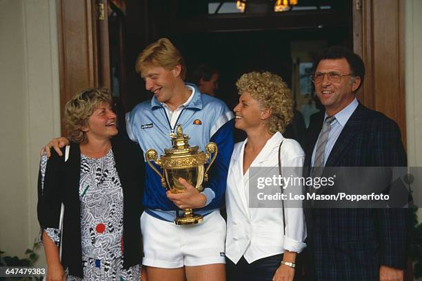 German tennis player Boris Becker pictured holding the Gentlemen's Singles Challenge CupTrophy with his mother Elvira, sister Sabine and father...