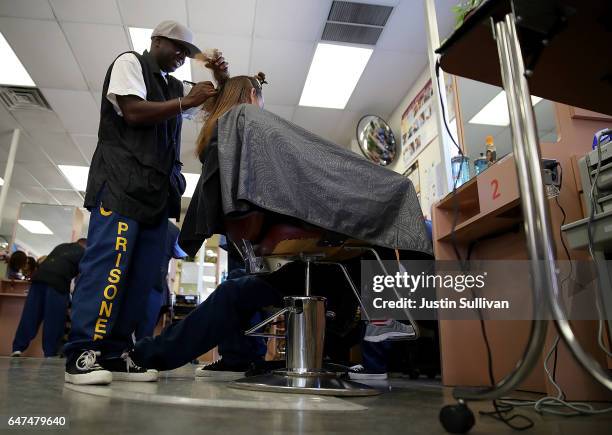 Valley State Prison inmate Will Caldwell cuts the hair of a prison employee during a cosmetology class at Valley State Prison on March 2, 2017 in...