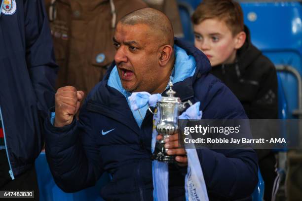 Manchester City fan hold a mini FA Cup during The Emirates FA Cup Fifth Round Replay between Manchester City and Huddersfield Town at the Etihad...