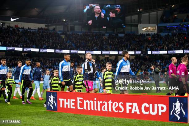 Huddersfield Town players enter the pitch at Etihad Stadium, home stadium of Manchester City during The Emirates FA Cup Fifth Round Replay between...