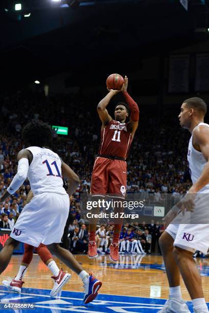 Kristian Doolittle of the Oklahoma Sooners shoots against Josh Jackson of the Kansas Jayhawks at Allen Fieldhouse on February 27, 2017 in Lawrence,...