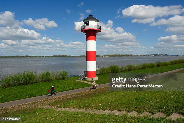 dyke and lighthouse, elbe river, altes land - cycle stock-fotos und bilder