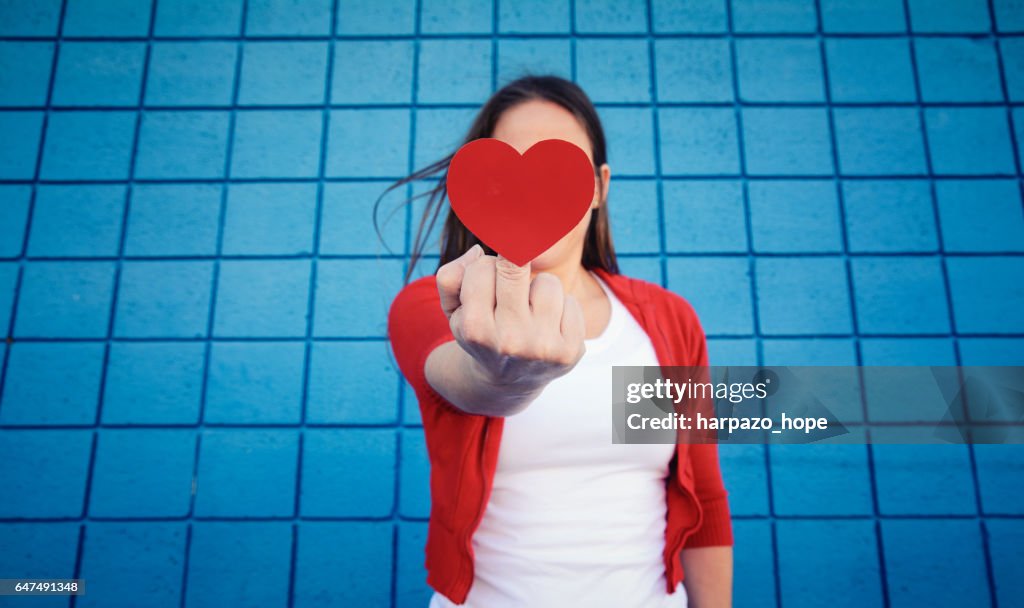 Woman with a heart on her middle finger.