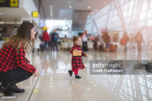 niedlichen kleinkind mädchen laufen in flughafenhalle - toddler at airport stock-fotos und bilder