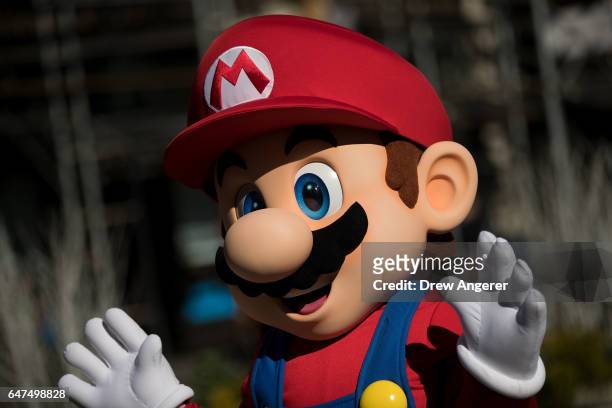 Person dressed as the Nintendo character Mario waves at a pop-up Nintendo venue in Madison Square Park, March 3, 2017 in New York City. The Nintendo...