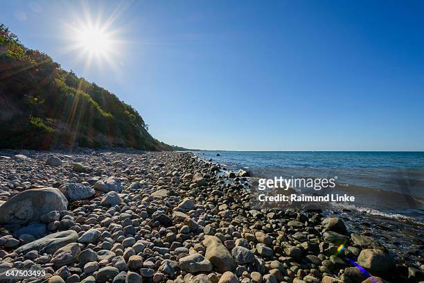 stone beach with sun - kattegat stock-fotos und bilder