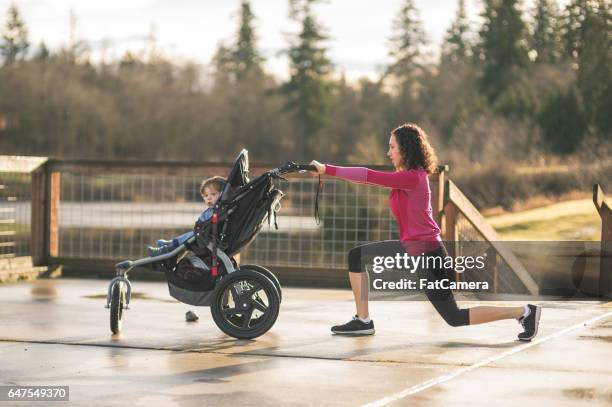 young mom stretching next to child in baby stroller - the stroller stock pictures, royalty-free photos & images