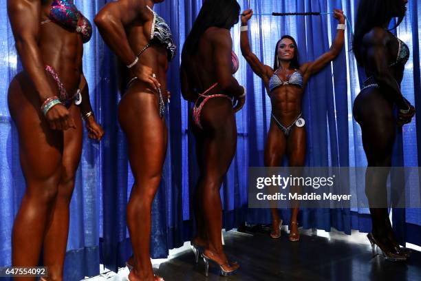 Kristine Duba, second from right, warms up backstage before the Fitness International competition prejudging at the Greater Columbus Convention...