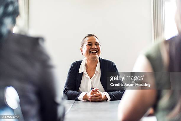 three businesswomen in conference room - candid office stock-fotos und bilder