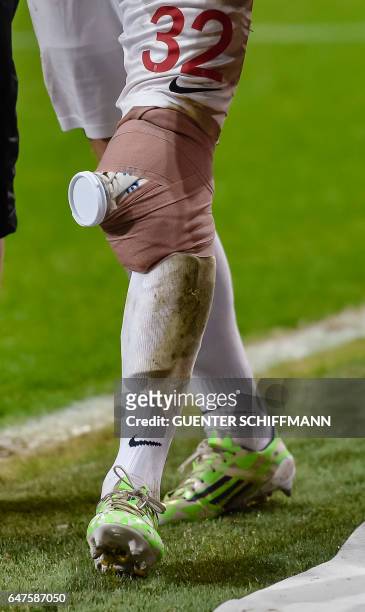 Injured Augsburg's German defender Raphael Framberger walks off with an ice pack taped to his knee during the German first division Bundesliga...