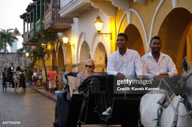 Of INDIAS, COLOMBIA A horse drawn carriage with two coachmen show around a foreign tourist in Puerta del Reloj at dusk on January 26, 2017 in...