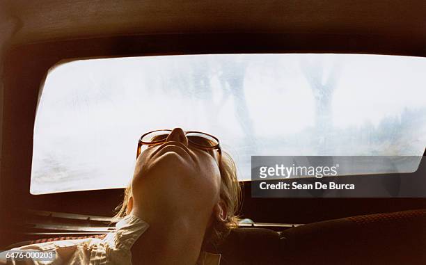 woman asleep in back of car - oblivious 個照片及圖片檔