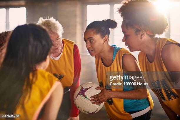 female netball team talking in gym. - drive ball sports fotografías e imágenes de stock