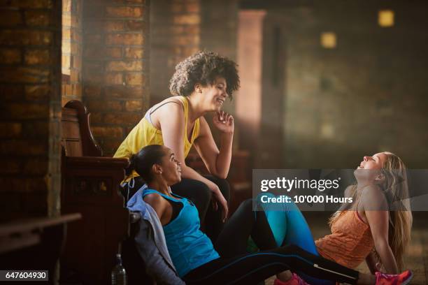 three young women wearing sports clothing talking in gym. - 3 gym stock-fotos und bilder