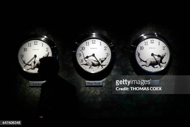 Man walks past a clock installation by Banksy at the street artist's newly opened Walled Off hotel in the Israeli occupied West Bank town of...