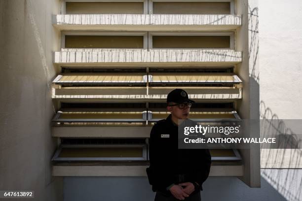 In this picture taken on March 2 a prison officer stands guard near the entrance to a block of cells at Stanley Prison in Hong Kong. Stanley Prison,...