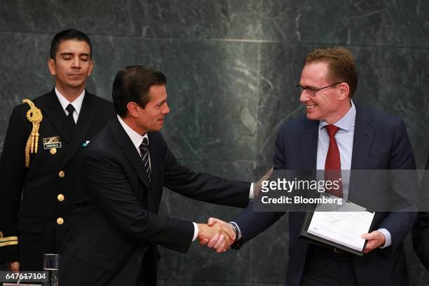 Enrique Pena Nieto, Mexico's president, left, shakes hand with Andrew Mackenzie, chief executive officer of BHP Billiton Ltd., during a signing...