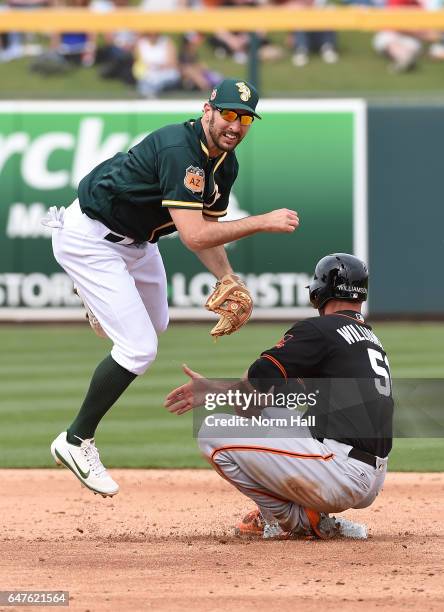 Adam Rosales of the Oakland Athletics attempts to turn a double play as Mac Williamson of the San Francisco Giants slides into second base during the...