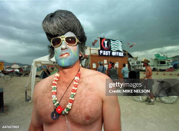 Mark, from Las Vegas, dressed as a blue faced Elvis Presley sneers near the Burning Man Post Office 05 September at the Burning Man Festival in the...