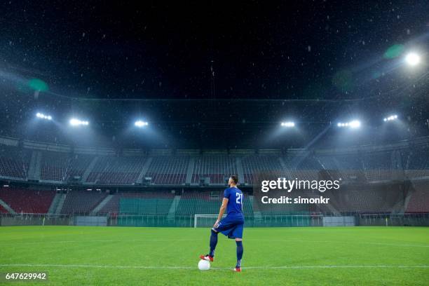 football-spieler stehen im stadion - stadion flutlicht stock-fotos und bilder