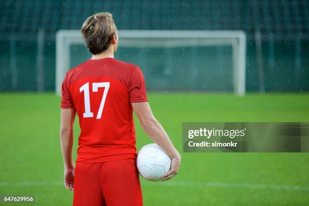 football player standing in stadium - football strip stock pictures, royalty-free photos & images