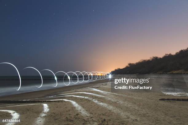spirale lichtlinien trail in der nacht - lichtspur stock-fotos und bilder