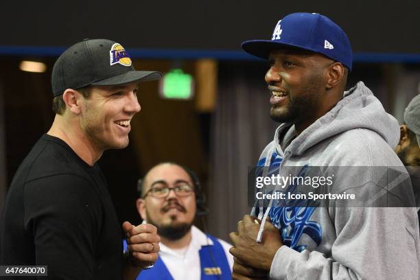 Los Angeles Lakers Head Coach Luke Walton talks with former Los Angeles Laker Lamar Odom during a college basketball game between the Washington...