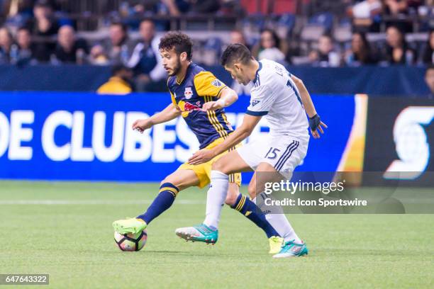 Vancouver Whitecaps midfielder Matias Laba defends against New York Red Bulls midfielder Felipe Martins during the CONCACAF Champions League...