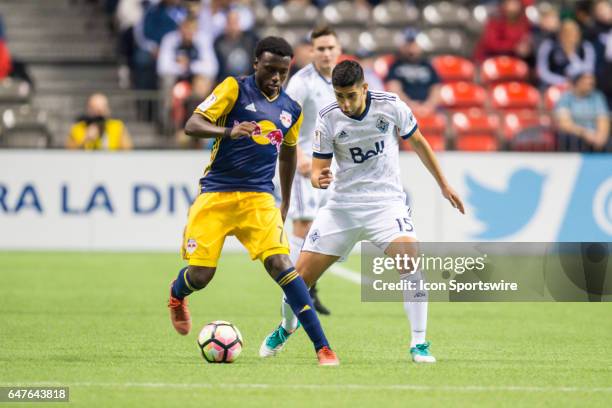 Vancouver Whitecaps midfielder Matias Laba defends against New York Red Bulls midfielder Derrick Etienne during the CONCACAF Champions League...