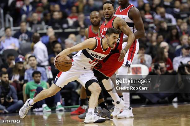 Tomas Satoransky of the Washington Wizards drives around Norman Powell of the Toronto Raptors in the first half at Verizon Center on March 3, 2017 in...