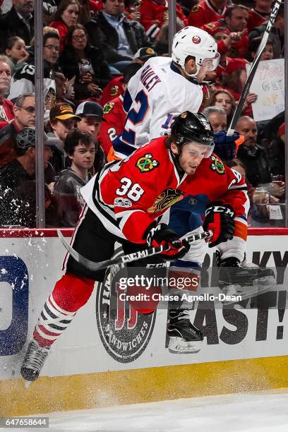 Josh Bailey of the New York Islanders checks Ryan Hartman of the Chicago Blackhawks in the second period at the United Center on March 3, 2017 in...