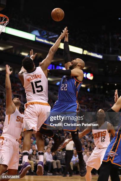 Taj Gibson of the Oklahoma City Thunder attempts a shot over Alan Williams of the Phoenix Suns during the first half of the NBA game at Talking Stick...