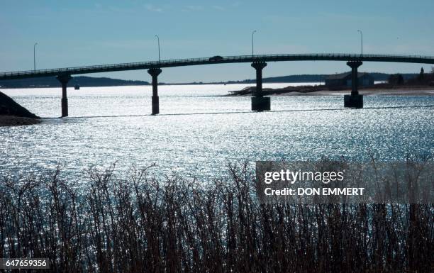 Cars cross over the International Bridge between Lubec, Maine and Campobello Island, Canada on March 3, 2017 as pictured from Campobello Island,...