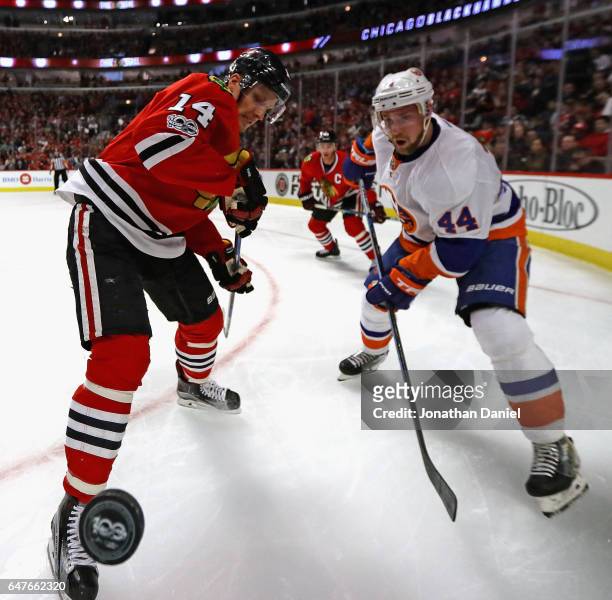 Richard Panik of the Chicago Blackhawks and Calvin de Haan of the New York Islanders battle for the puck in the corner at the United Center on March...